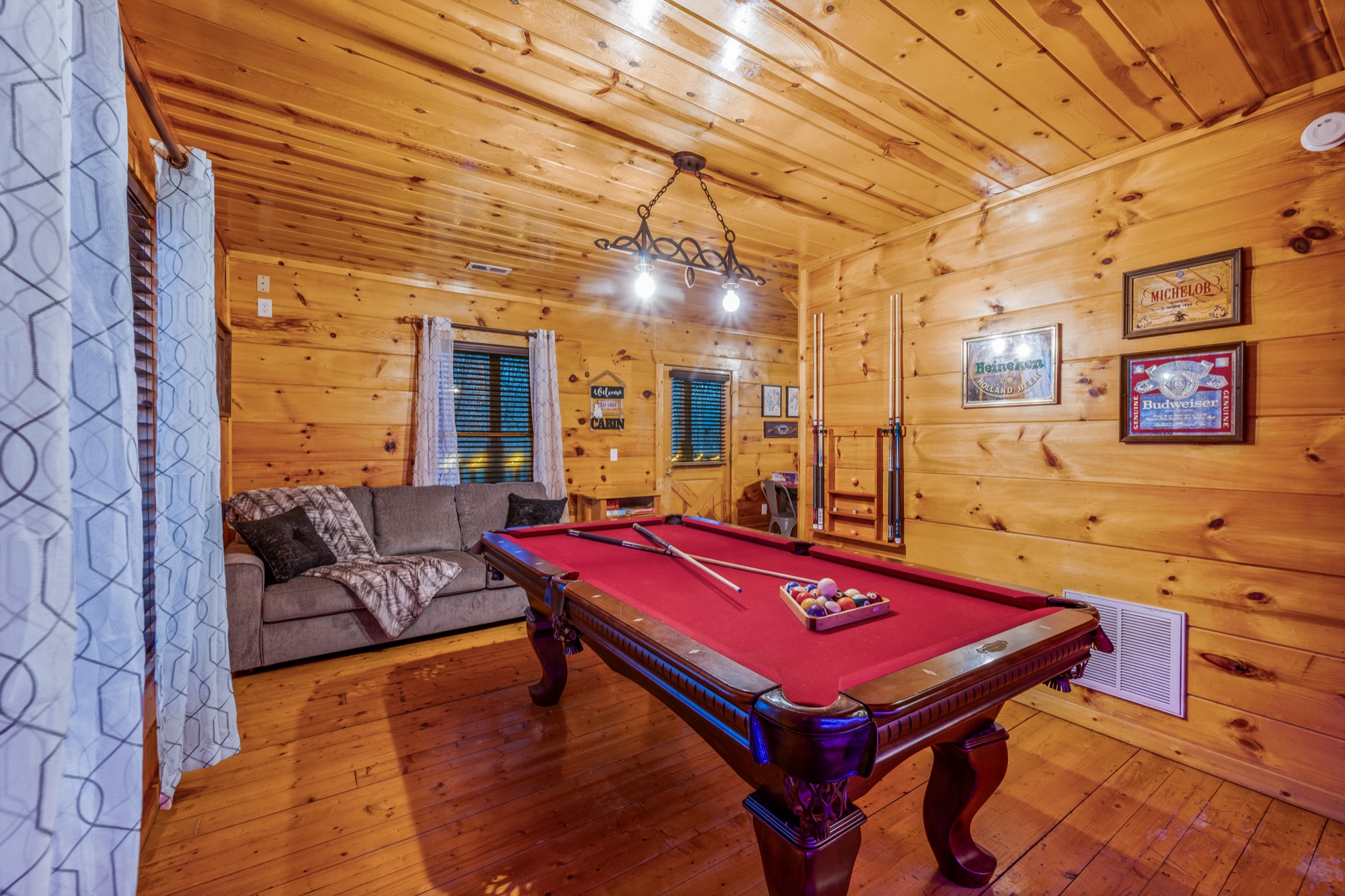 Bearadise game room with a pool table, cue rack, and a wall of vintage beer signs